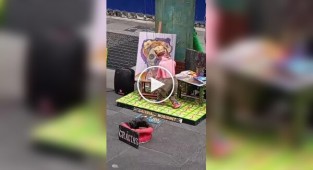 Художник малює картини за допомогою маріонетки